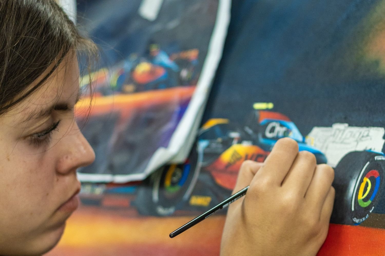 student painting a racecar